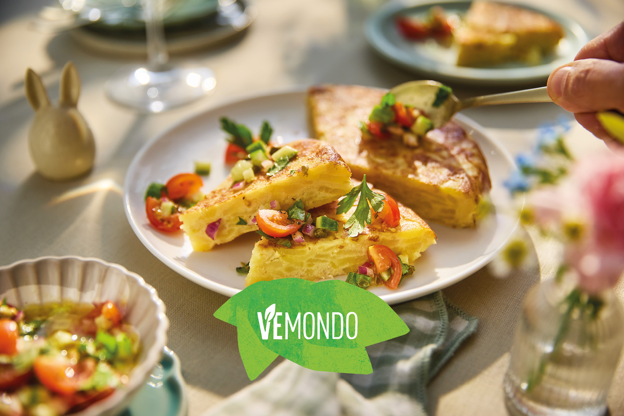 Fette di frittata di patate con salsa fresca su un tavolo da pranzo all'aperto.