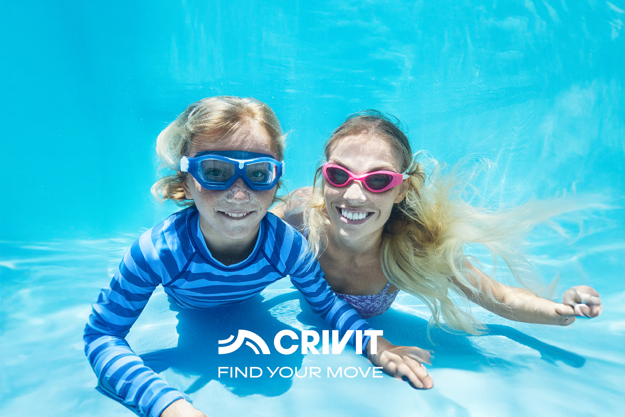 Due persone sorridenti sott'acqua con occhialini da nuoto, una con maglia a maniche lunghe a righe.