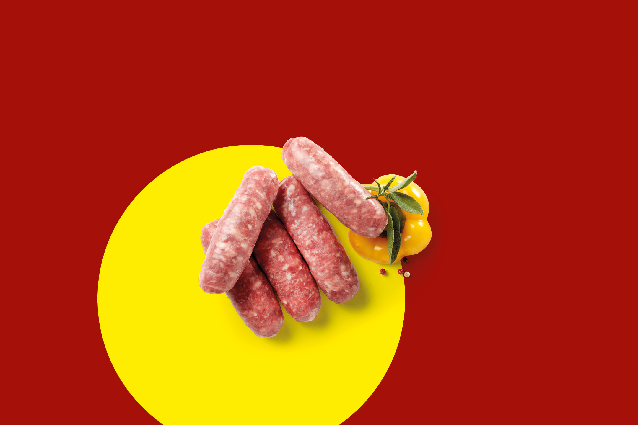 Salsicce fresche con peperone giallo e erbe aromatiche su sfondo rosso e giallo.
