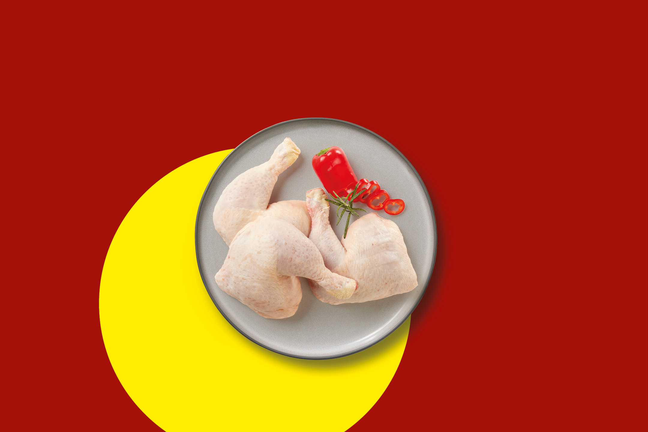 Cosce di pollo crude su un piatto grigio con peperoni rossi e rosmarino, su sfondo rosso e giallo.