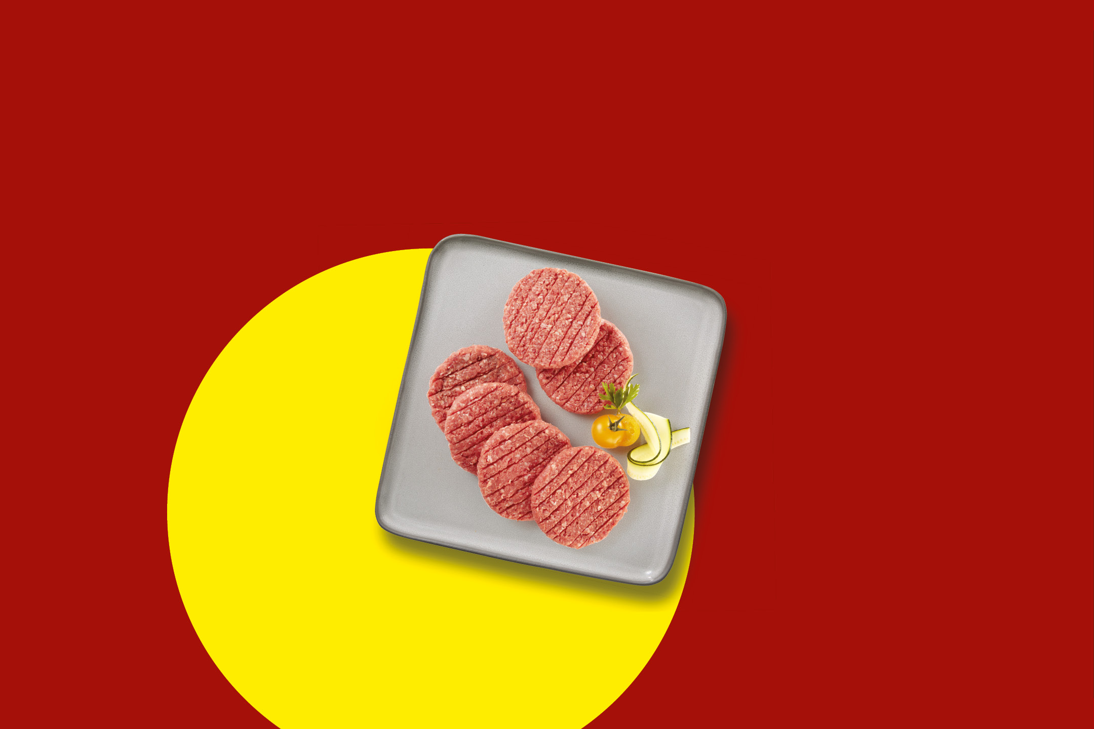 Sette hamburger di carne cruda su un piatto grigio, con guarnizioni di pomodoro e zucchine, su sfondo rosso e giallo.