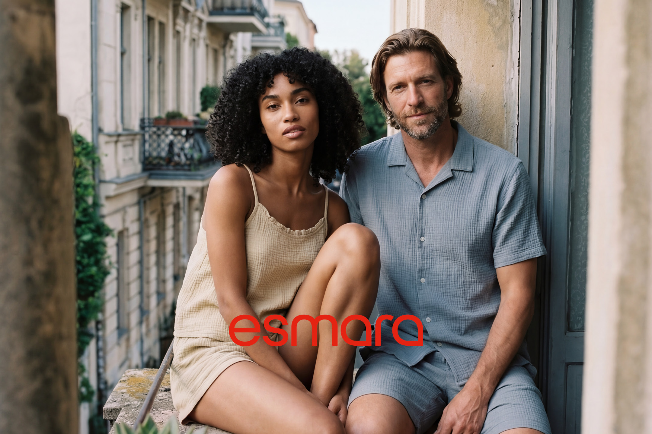 Una donna e un uomo in abiti estivi leggeri, con il logo del marchio in rosso.