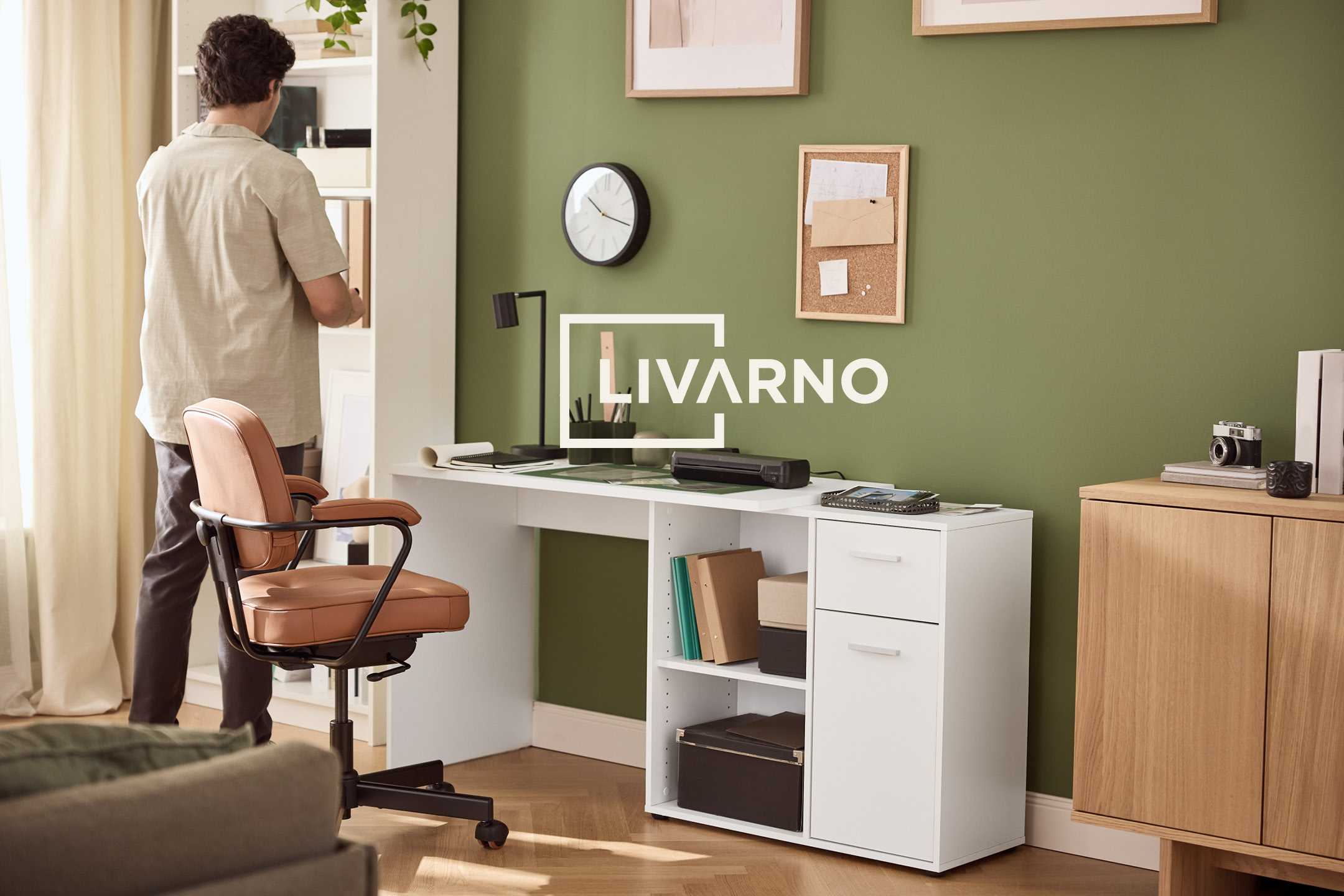 Ufficio domestico con scrivania bianca, sedia in pelle marrone e parete verde, con il logo 'LIVARNO'.