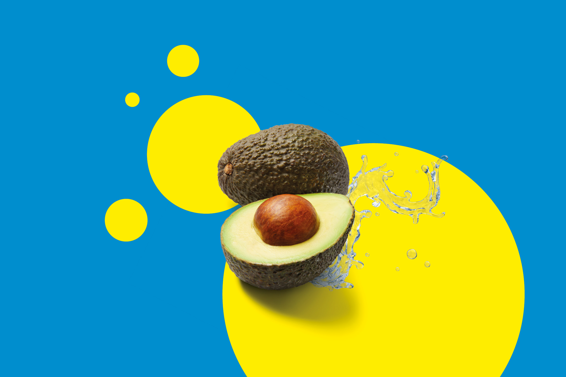 Avocado intero e tagliato a metà con schizzi d'acqua su sfondo blu e giallo.