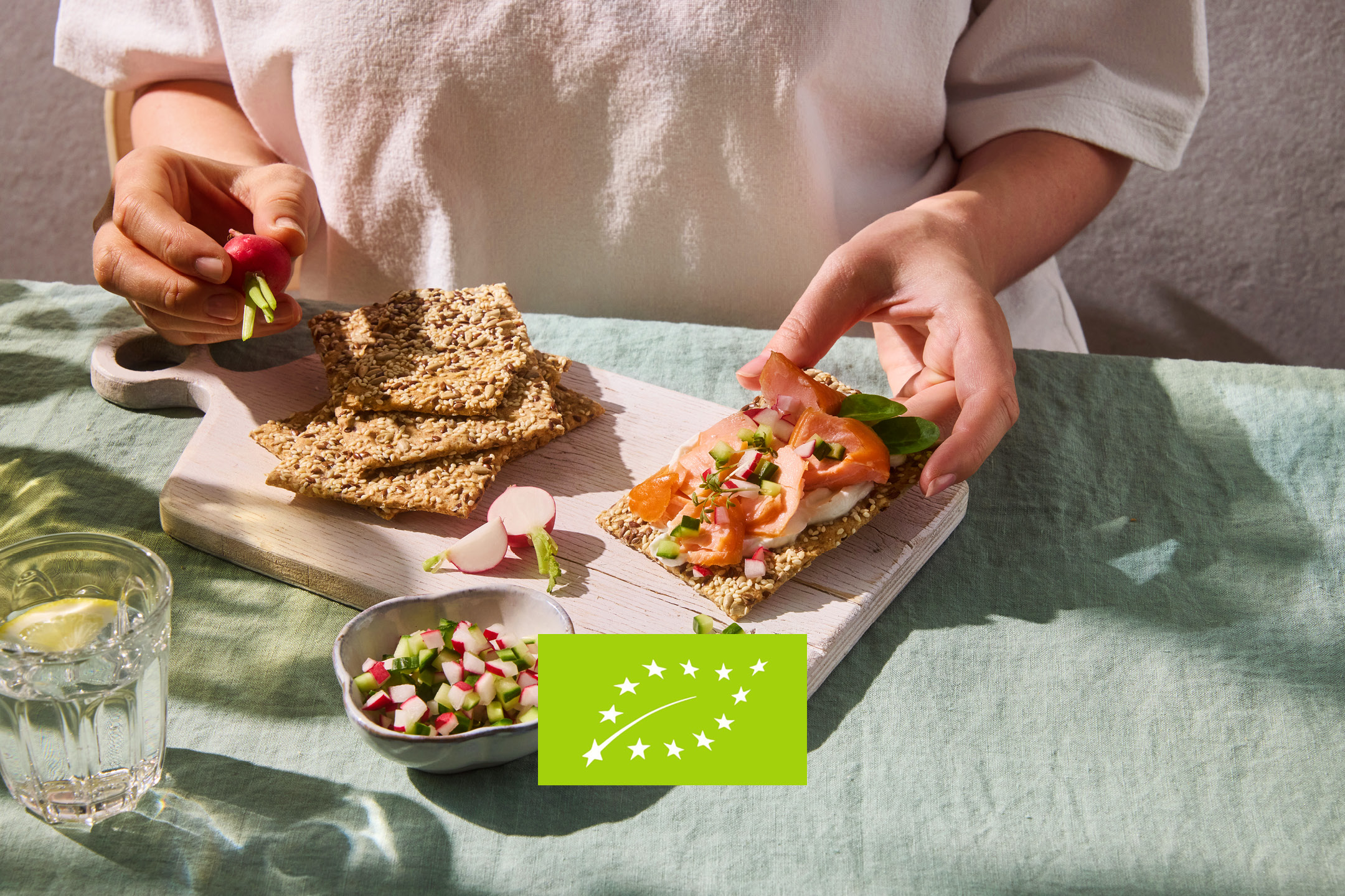 Cracker di semi con salmone e verdure, con logo biologico dell'UE.