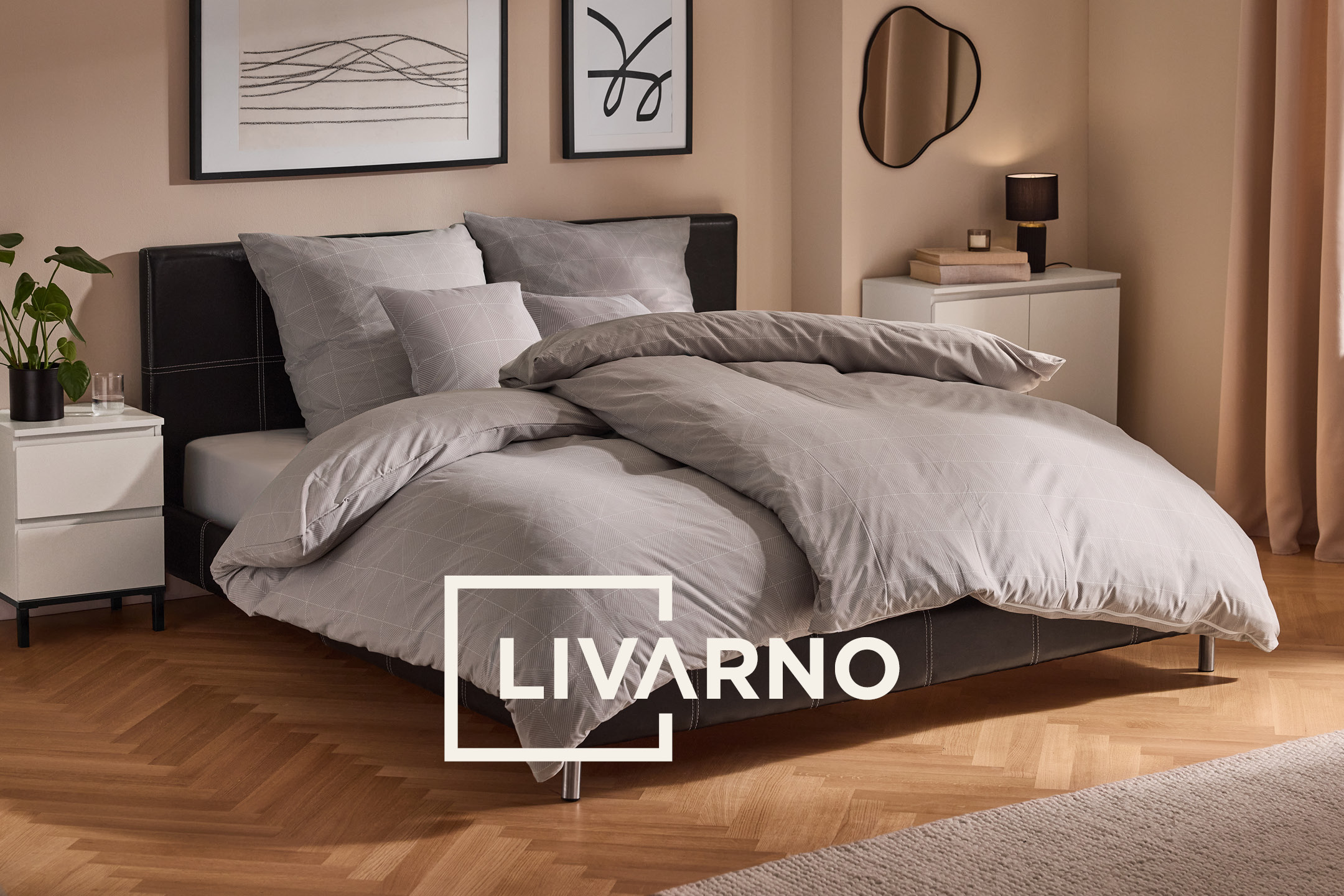 Letto matrimoniale con biancheria da letto grigia a motivi geometrici in una camera moderna.