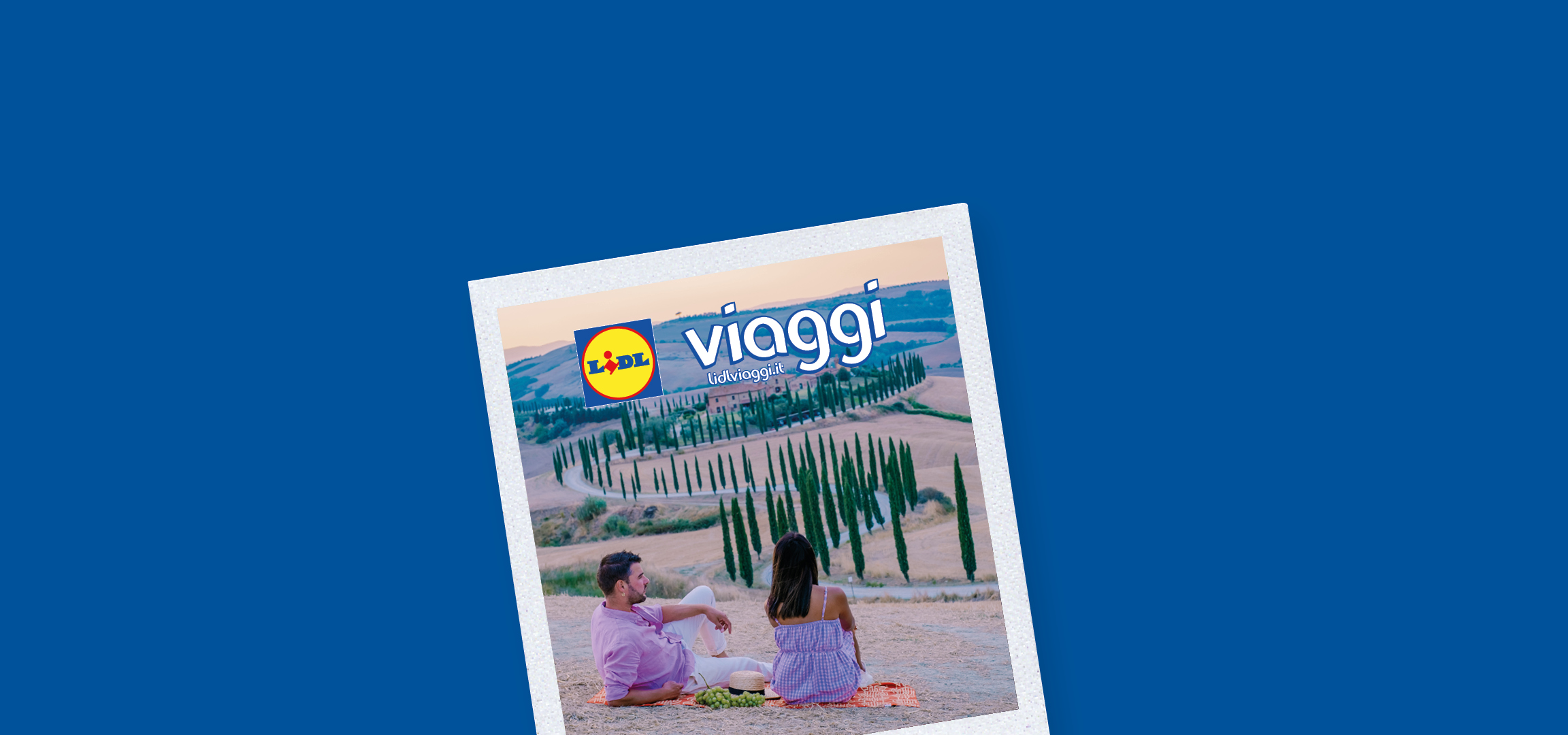 Paesaggio toscano con cipressi e una strada tortuosa che porta a una casa colonica, con il logo Lidl Viaggi.