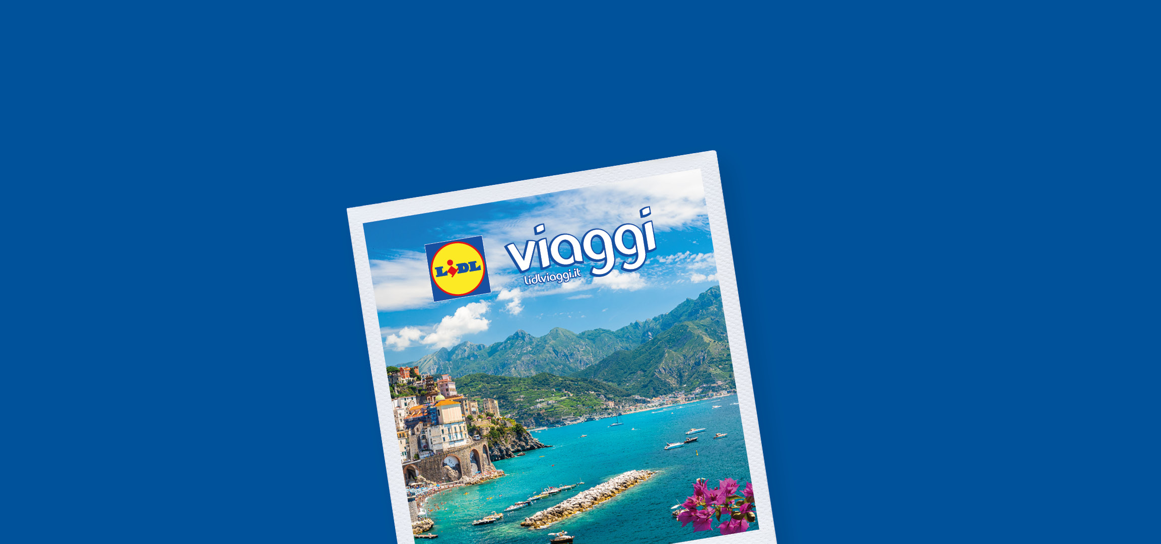 Un pittoresco villaggio costiero italiano con case colorate, montagne verdi e un mare blu intenso.