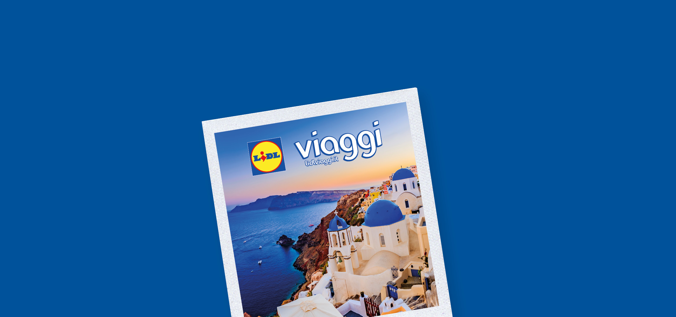 Panorama di Santorini con case bianche e cupole blu, mare e cielo al tramonto, con logo Lidl Viaggi.