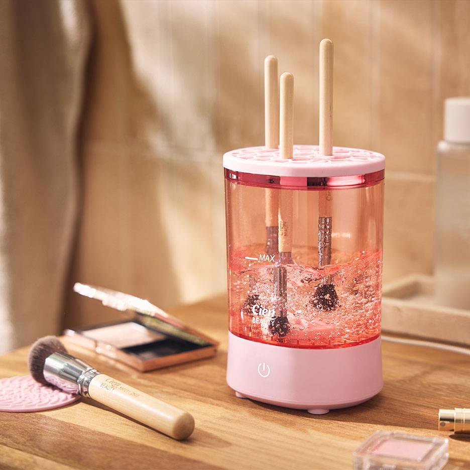 Pulitore rosa per pennelli da trucco con pennelli in acqua frizzante.