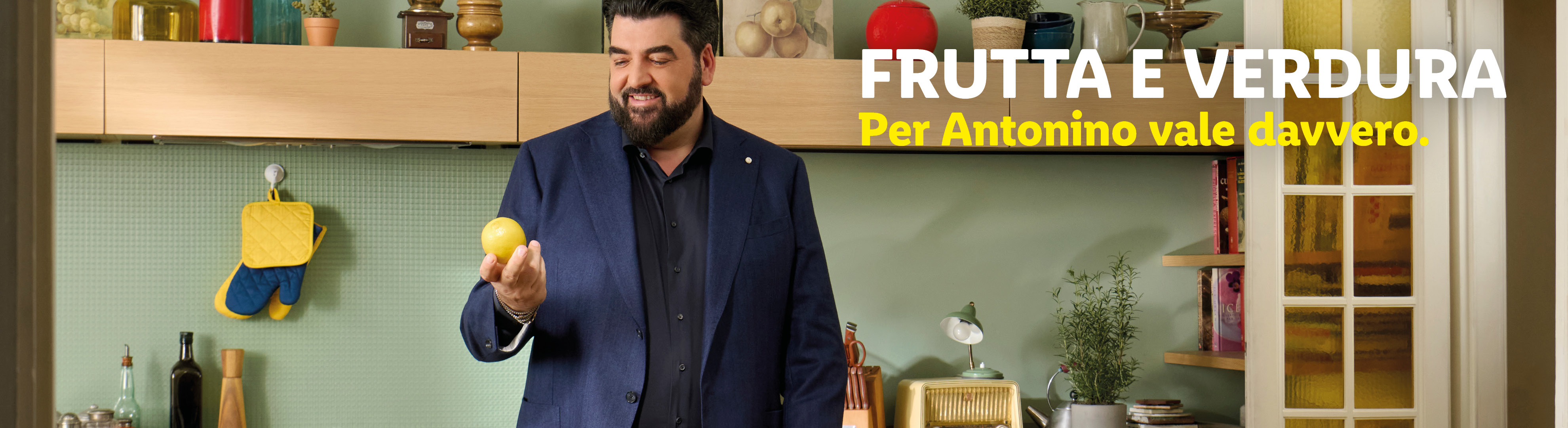 Chef sorridente in cucina con un limone in mano, testo: FRUTTA E VERDURA Per Antonino vale davvero.