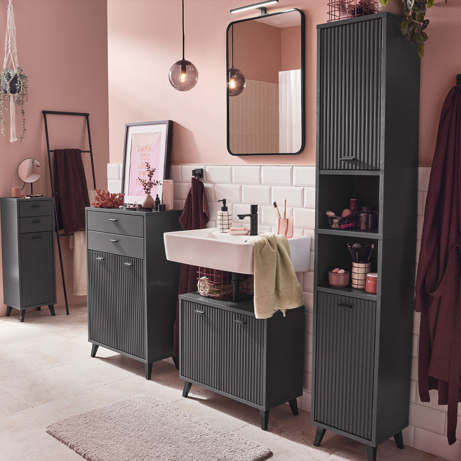 Bagno moderno con mobili grigio scuro e accenti rosa.