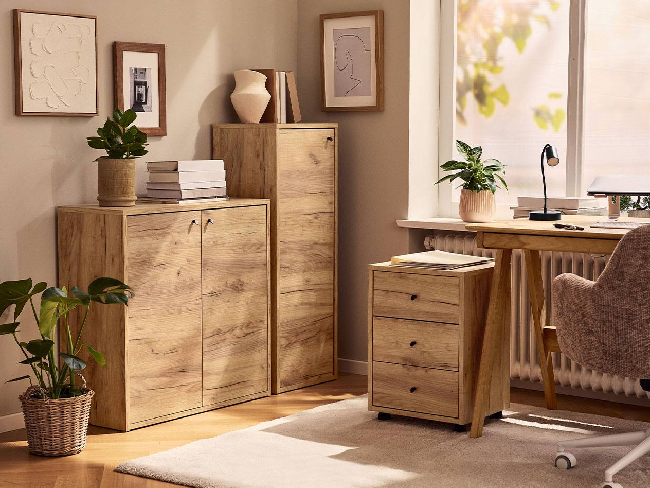 Un ufficio domestico con armadi in legno chiaro, una sedia da ufficio e una lampada da scrivania.