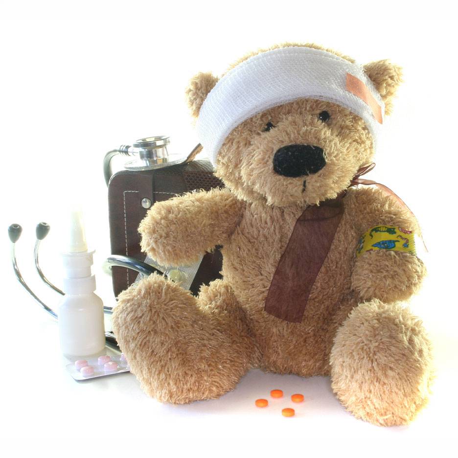 Orsetto di peluche ferito con benda, borsa medica, stetoscopio e medicine.