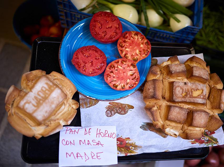 Pomodori freschi e pane fatto in casa con lievito madre al mercato.