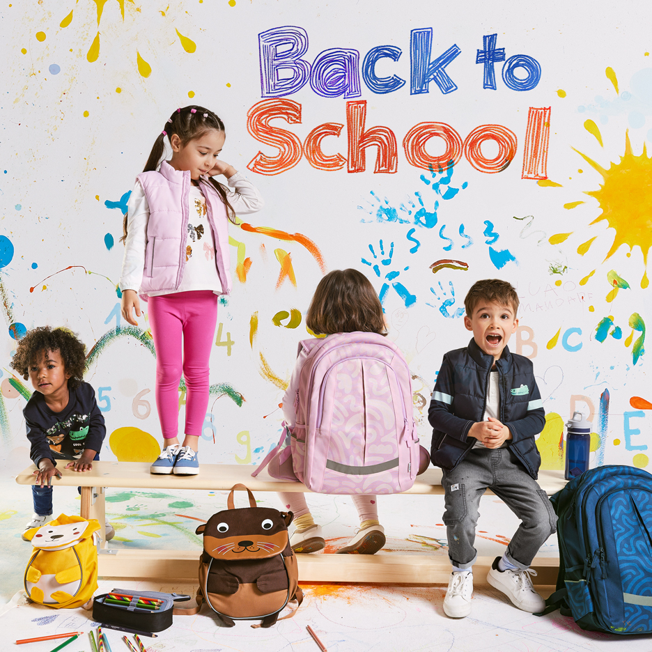 Quattro bambini con zaini e materiale scolastico, con la scritta 'Back to School' su uno sfondo colorato.