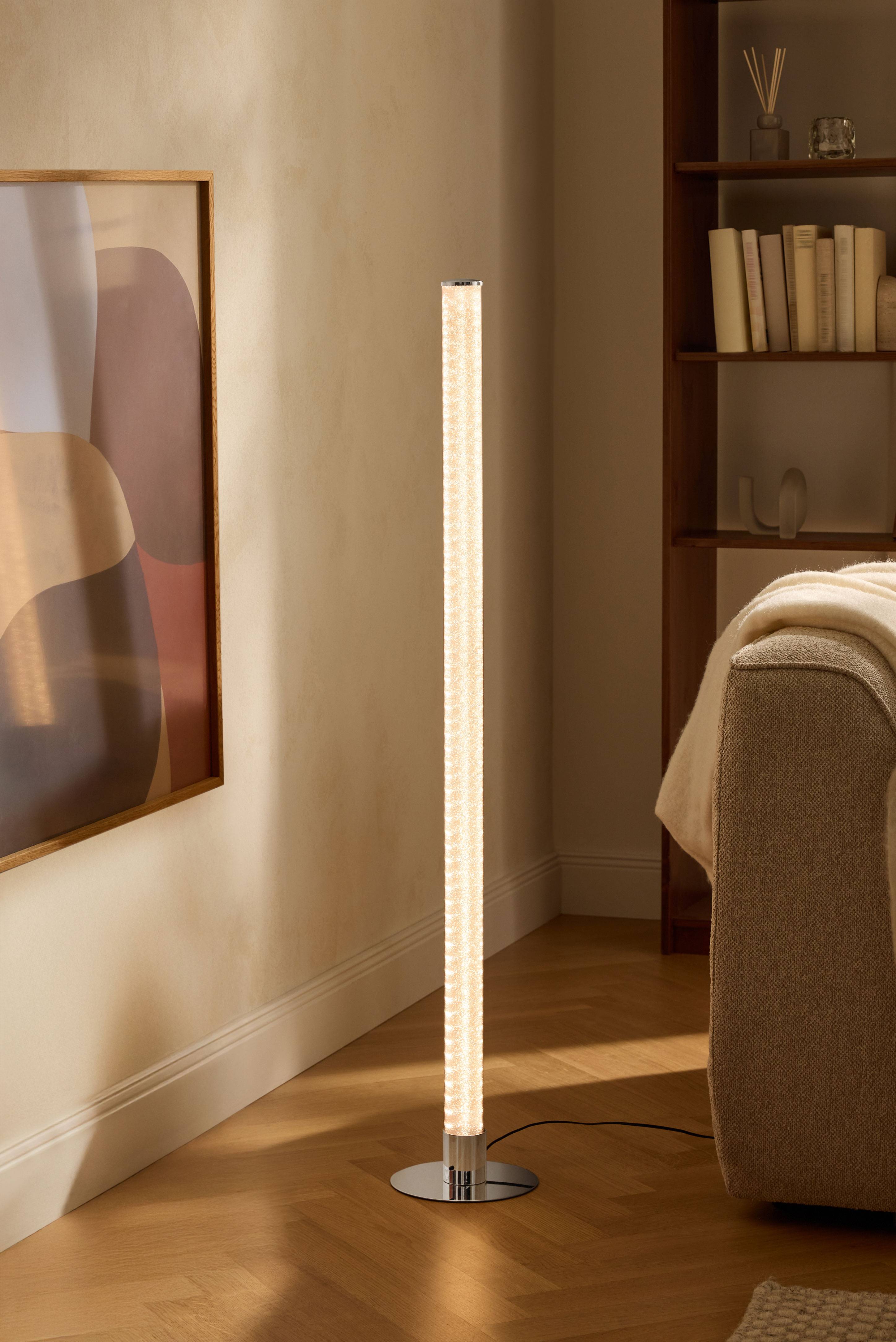 Lampada da terra moderna in soggiorno con libreria e divano.