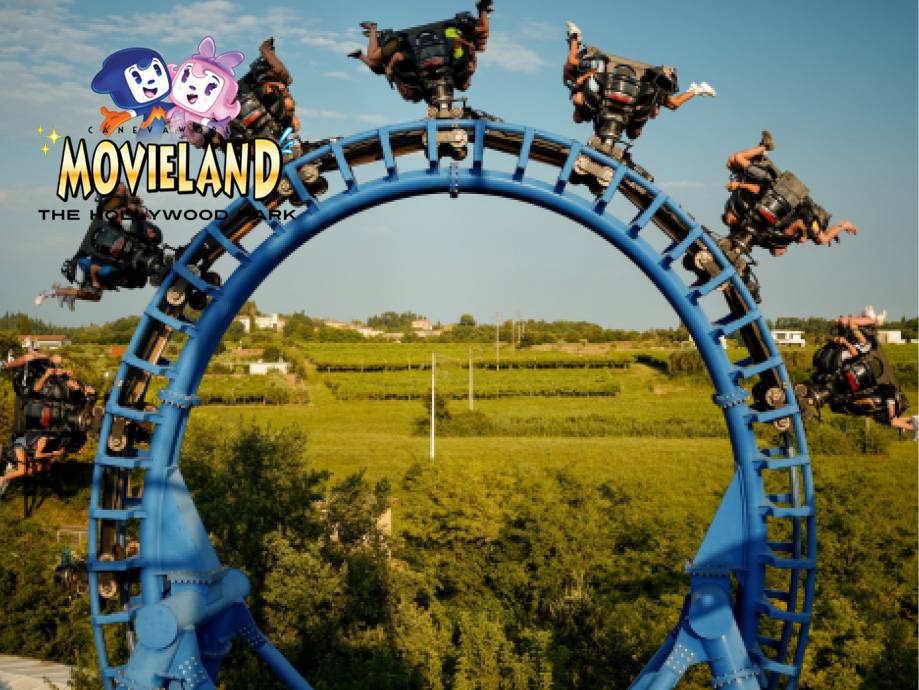 Montagne russe blu con persone a testa in giù, sullo sfondo un paesaggio verde e il logo 'Movieland'.