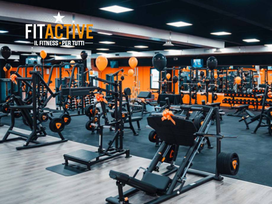 Una palestra FitActive con macchine per l'allenamento con i pesi e palloncini arancioni e neri.