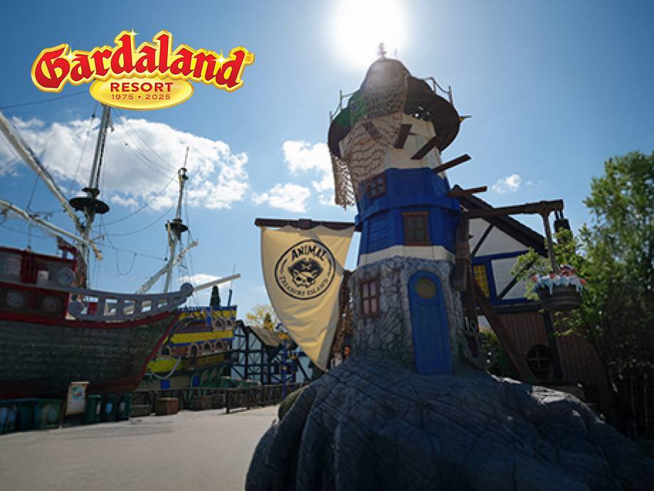 Un parco divertimenti con una nave pirata e una torre a tema, con il logo Gardaland Resort.