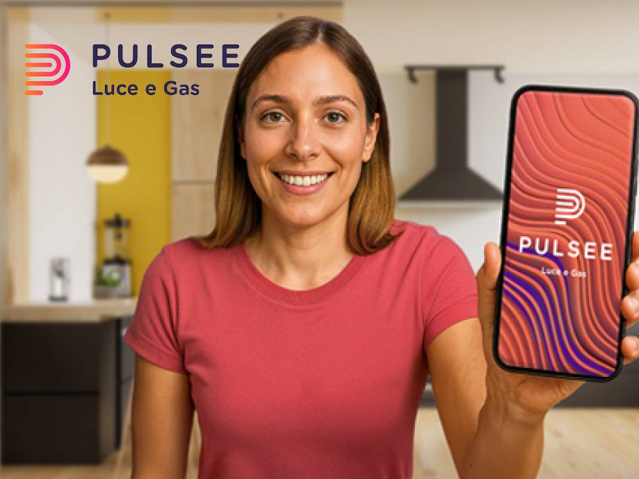 Una donna sorridente mostra un telefono con l'app Pulsee, con il logo Pulsee Luce e Gas.