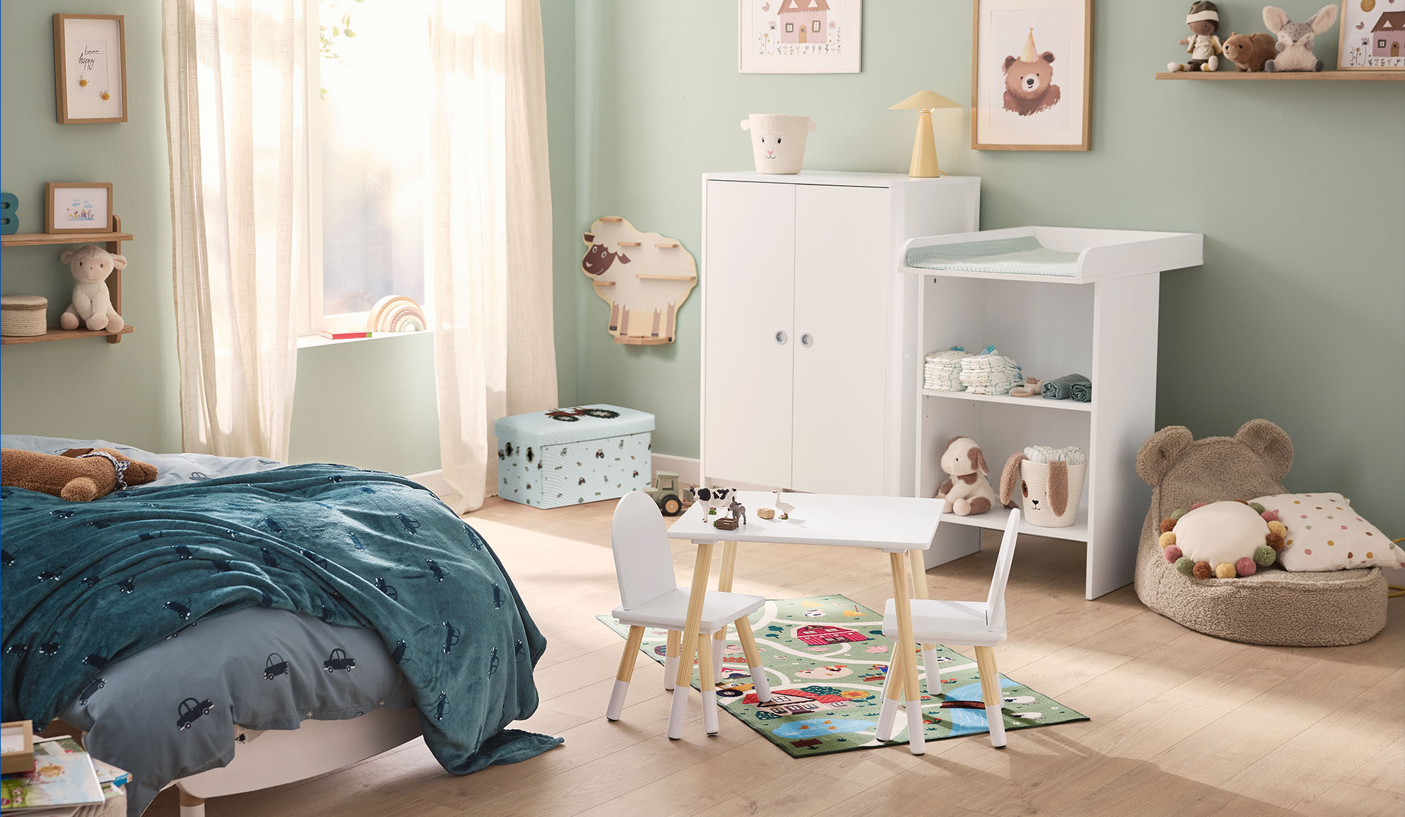 Stanza dei bambini con letto, fasciatoio, armadio e tavolo da gioco con sedie.