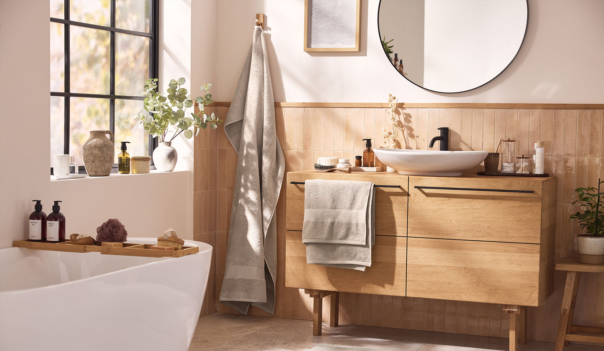 Bagno moderno con mobili da bagno in legno, una vasca da bagno e una finestra.