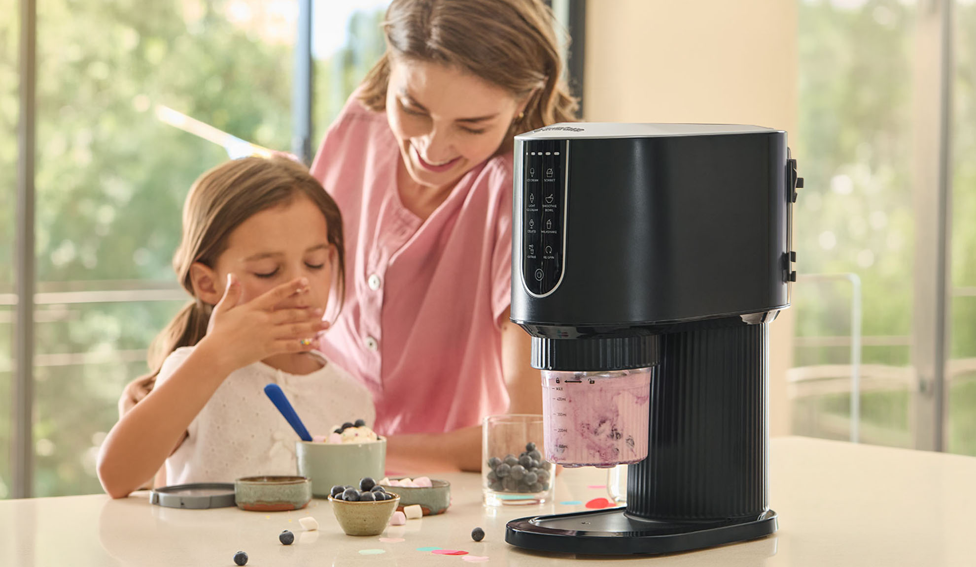 Gelatiera con una bambina e una donna che preparano il gelato.