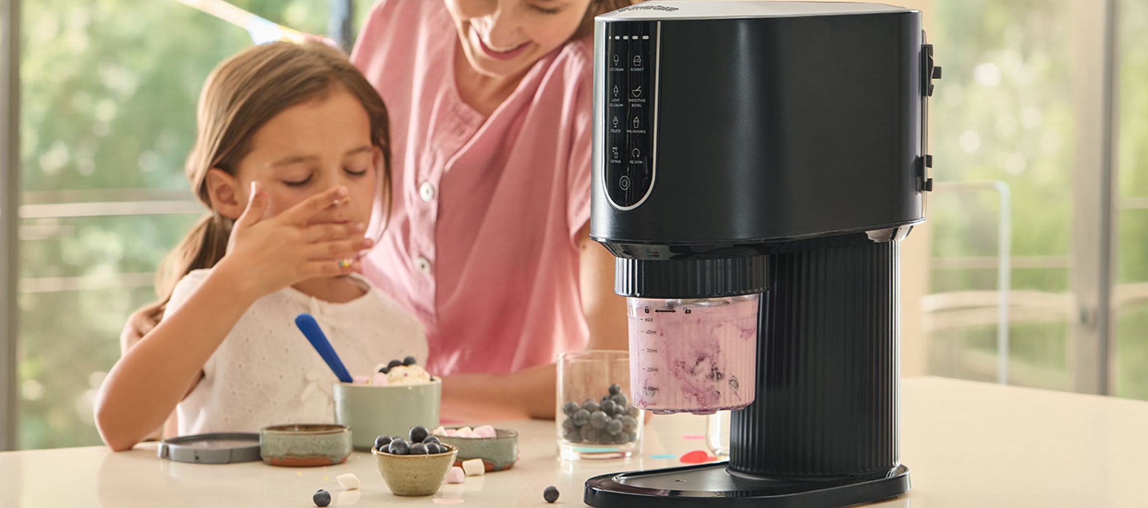 Gelatiera che prepara gelato ai frutti di bosco, bambino e adulto che gustano il dessert.