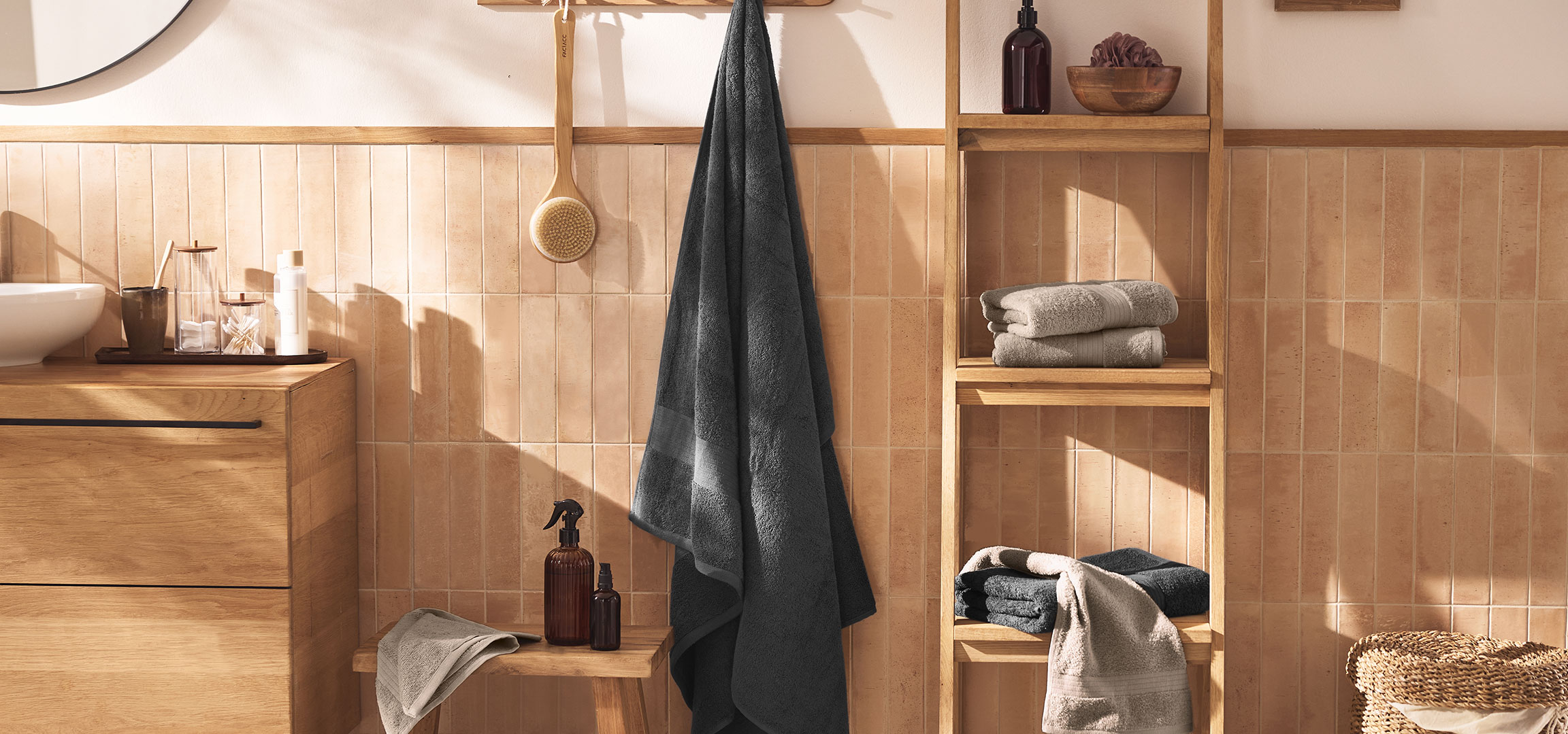 aiLabeling.aiLabelForImageAltText: Bagno moderno con lavabo, mobile in legno, asciugamani e accessori.