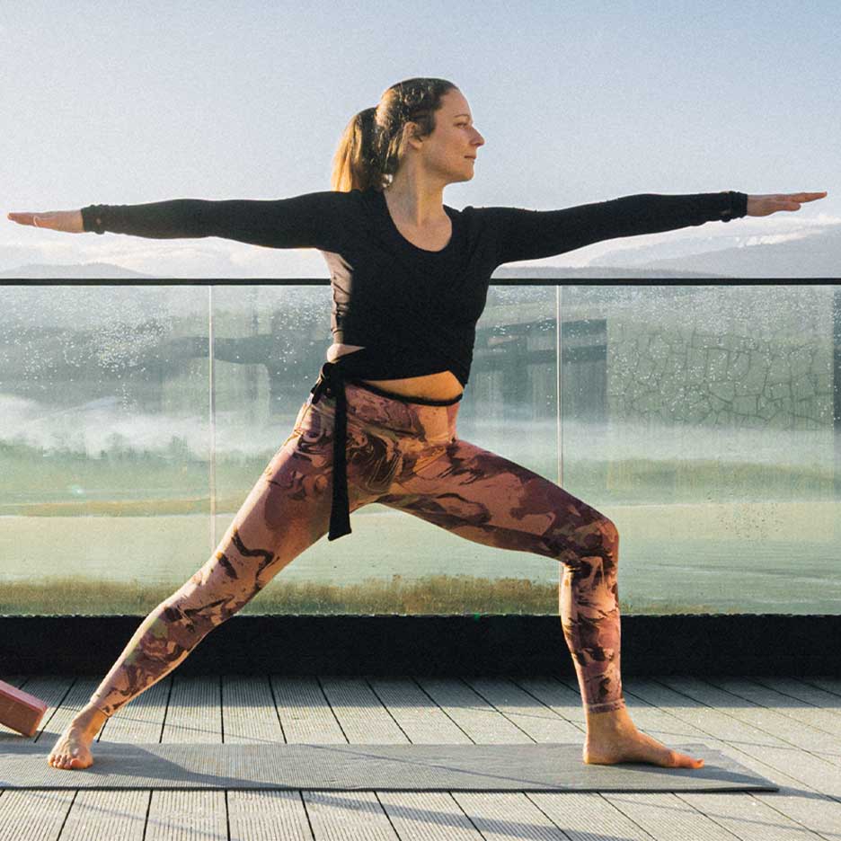Donna in leggings e top da yoga su una terrazza