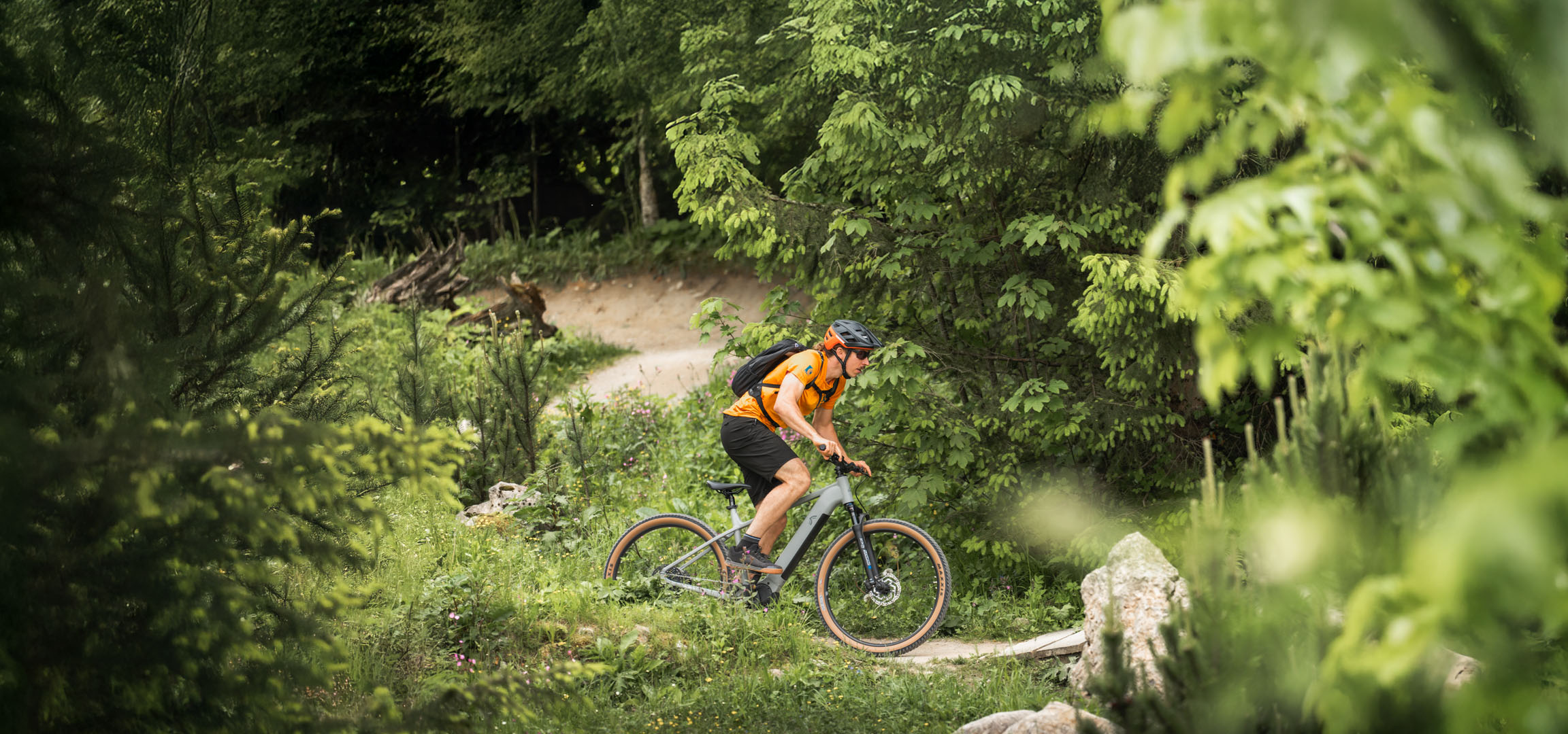 Un ciclista si gode un giro in e-bike su un sentiero nel bosco.